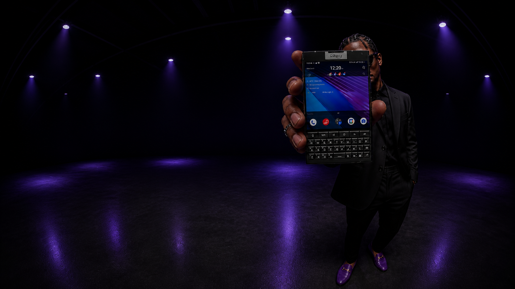 A person in a black suit holding a square keyboard phone running Ripe under purple studio light.
